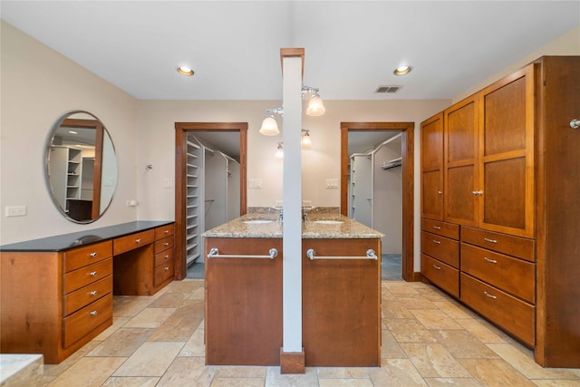 kitchen with light tile patterned flooring, sink, kitchen peninsula, and decorative light fixtures