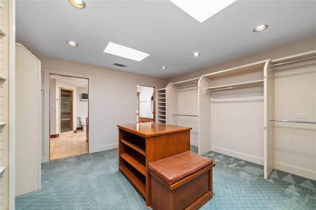 walk in closet featuring a skylight and carpet flooring