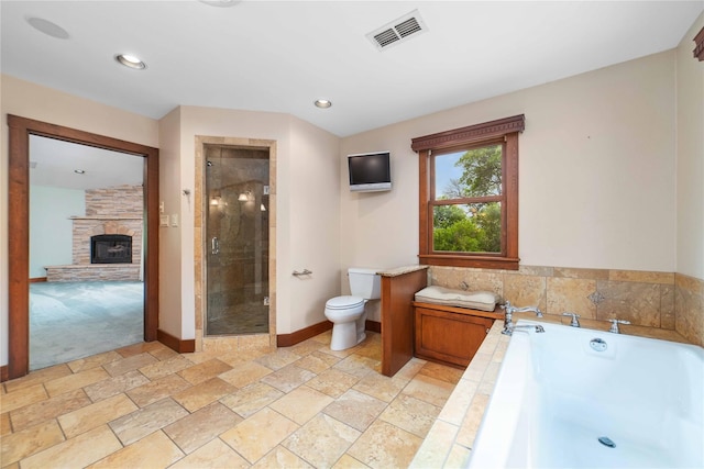 bathroom featuring tile patterned floors, a fireplace, shower with separate bathtub, and toilet