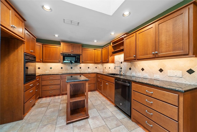 kitchen with sink, tasteful backsplash, light tile patterned flooring, black appliances, and a center island