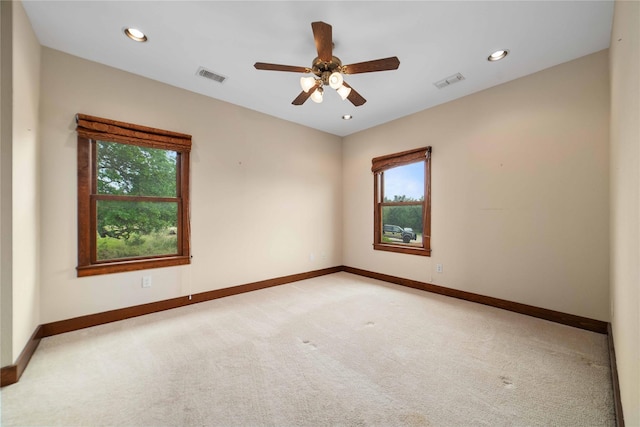 carpeted spare room with ceiling fan and a wealth of natural light