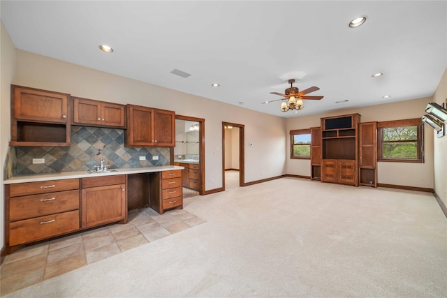 kitchen with light carpet, ceiling fan, sink, and decorative backsplash