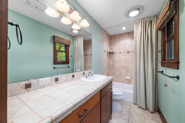 full bathroom with shower / bath combo with shower curtain, tile patterned floors, vanity, and toilet