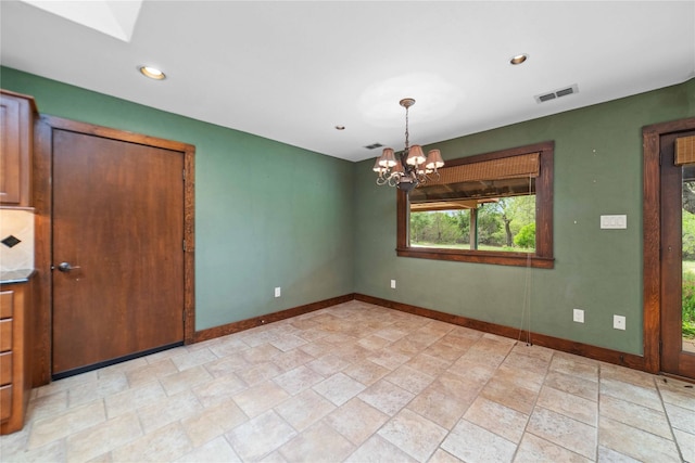 unfurnished dining area with a notable chandelier and light tile patterned floors