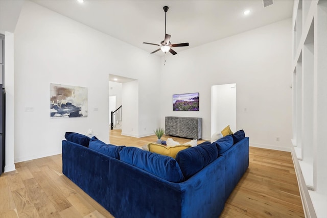 living room with ceiling fan, high vaulted ceiling, and light hardwood / wood-style floors