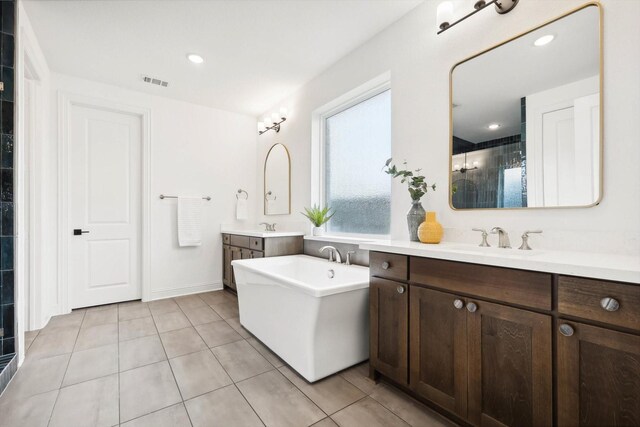 bathroom featuring vanity, a bathtub, and tile patterned flooring