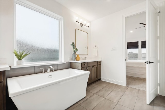 bathroom featuring ceiling fan, a bathing tub, vanity, and tile patterned flooring