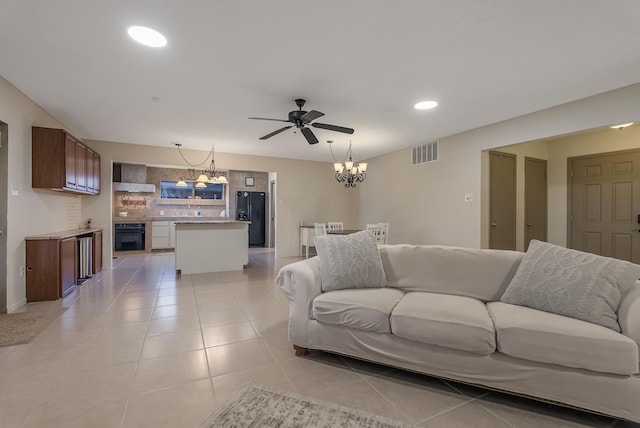 living room featuring light tile patterned floors and ceiling fan with notable chandelier