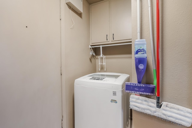 clothes washing area with cabinets