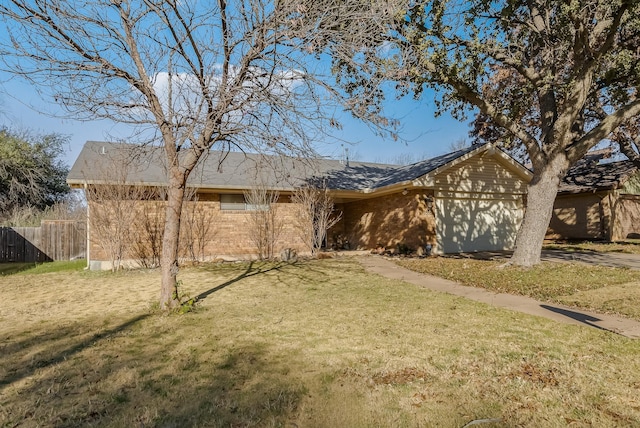 single story home featuring a garage and a front lawn