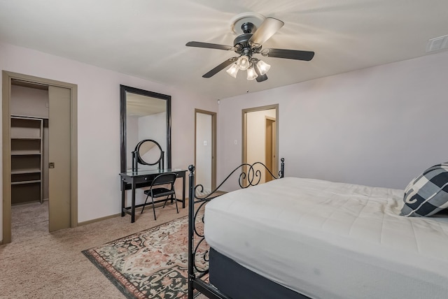 bedroom with carpet flooring, ceiling fan, a walk in closet, and a closet