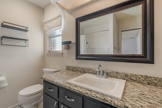 bathroom featuring vanity, a shower with shower curtain, and toilet