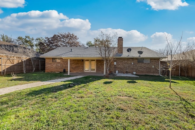 back of house with a patio area and a lawn