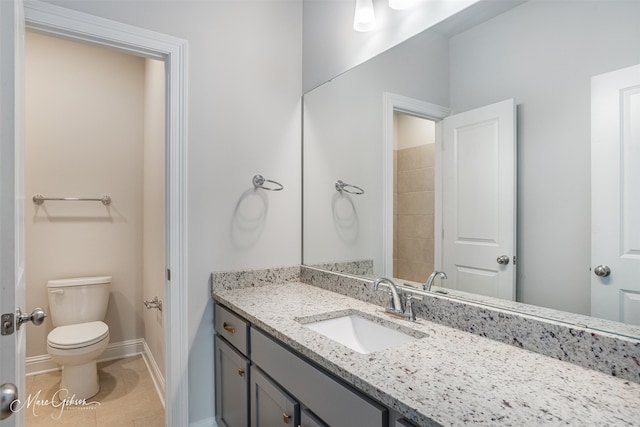 bathroom featuring vanity, tile patterned flooring, and toilet