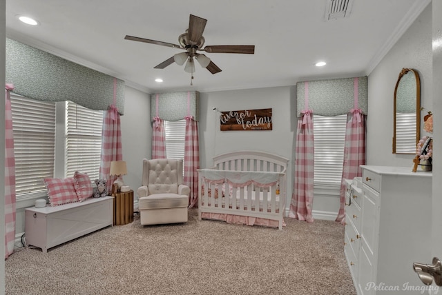 bedroom with ceiling fan, a nursery area, light carpet, and crown molding