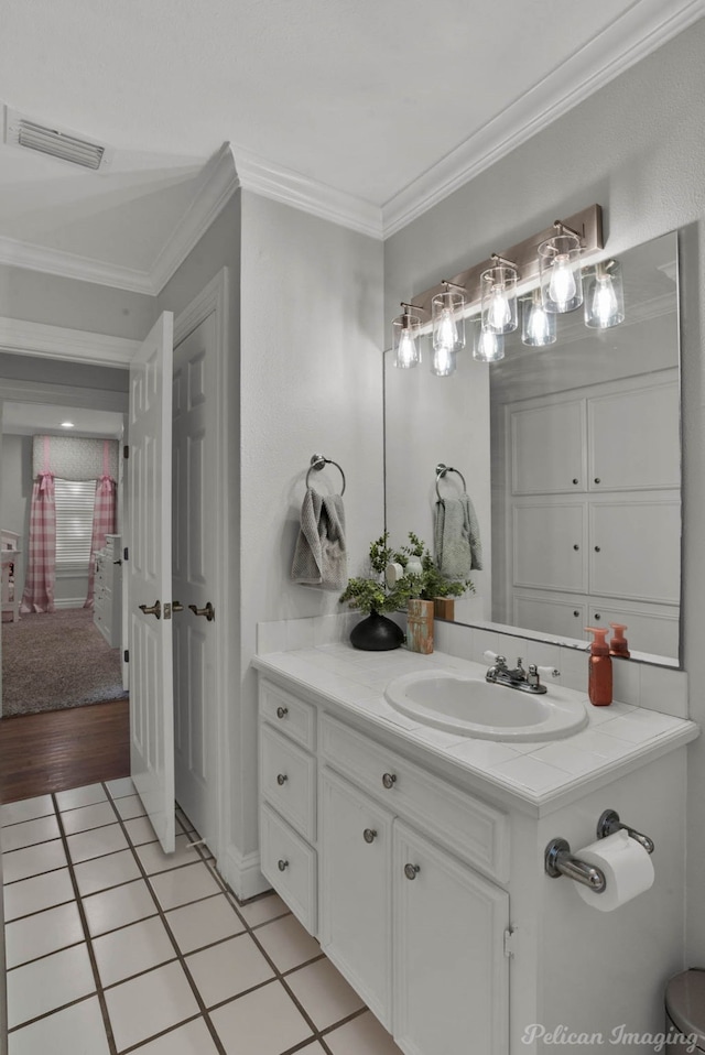 bathroom with crown molding, vanity, and tile patterned flooring