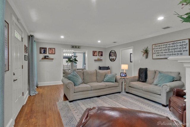 living room with ornamental molding and light hardwood / wood-style floors