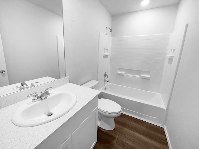 full bathroom with hardwood / wood-style flooring, washtub / shower combination, vanity, and toilet