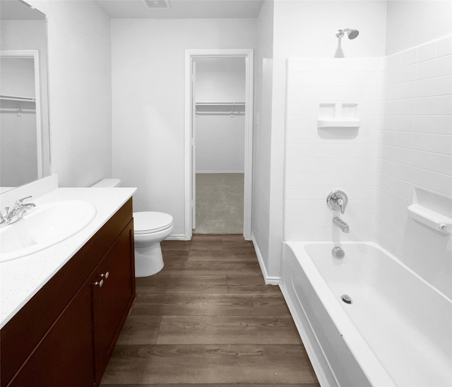 full bathroom with wood-type flooring, tub / shower combination, vanity, and toilet