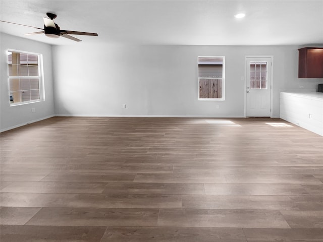 unfurnished living room featuring ceiling fan and hardwood / wood-style floors