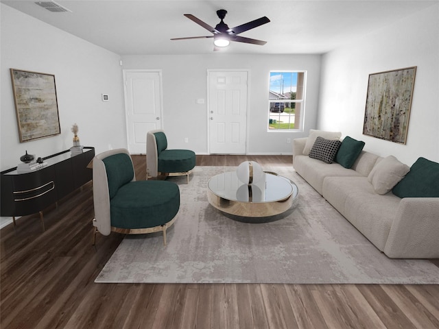 living room featuring dark wood-type flooring and ceiling fan