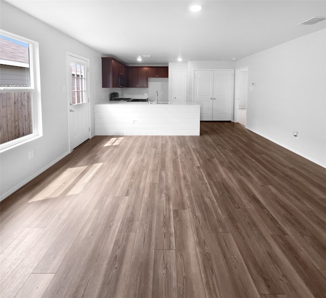 unfurnished living room with hardwood / wood-style floors and sink