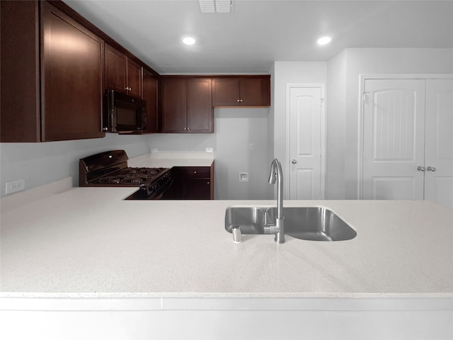 kitchen with sink, black appliances, and dark brown cabinetry