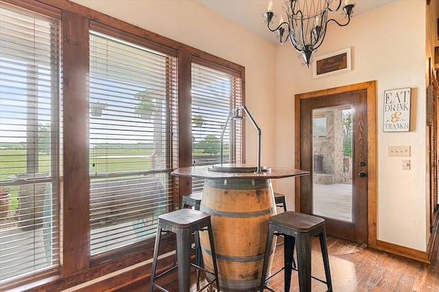 dining space with wood-type flooring and an inviting chandelier