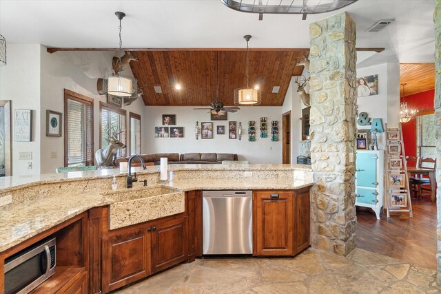 kitchen with light wood-type flooring, ceiling fan with notable chandelier, pendant lighting, appliances with stainless steel finishes, and light stone counters