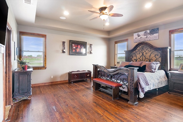 bedroom featuring hardwood / wood-style floors, ceiling fan, and a raised ceiling