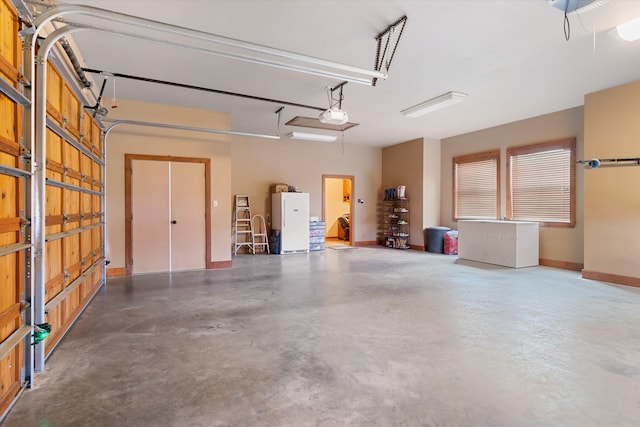 garage featuring a garage door opener and white refrigerator