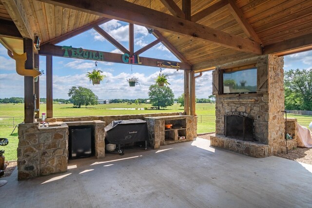 view of patio with an outdoor stone fireplace and a gazebo