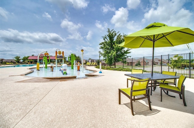 view of play area with a community pool and a patio