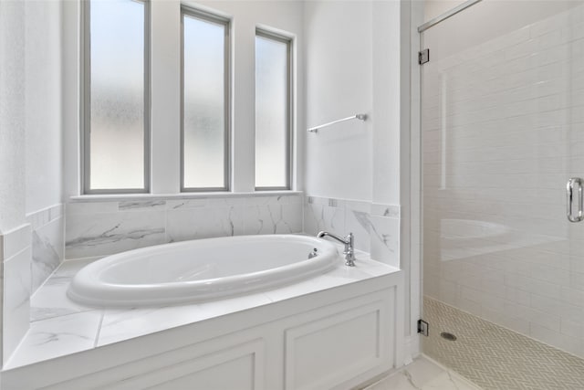 bathroom featuring tile walls, separate shower and tub, and plenty of natural light