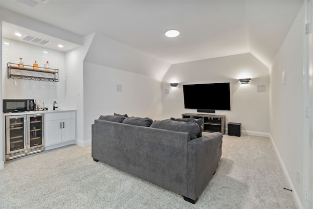 living room with light carpet, beverage cooler, wet bar, and vaulted ceiling