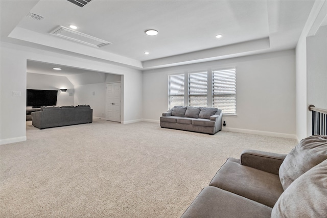 carpeted living room with a raised ceiling