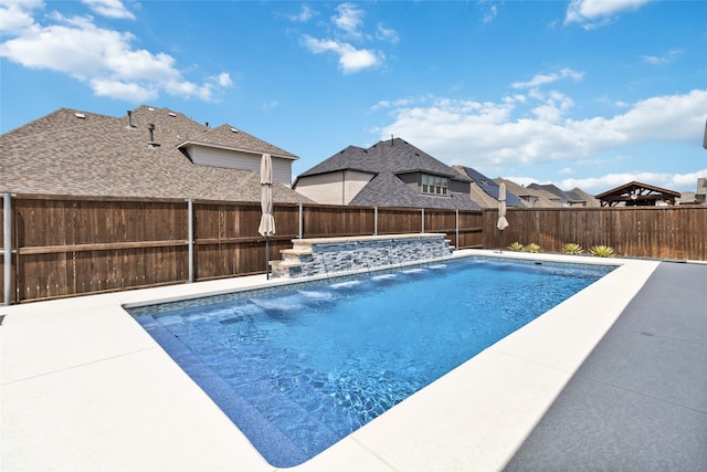 view of swimming pool with pool water feature and a patio