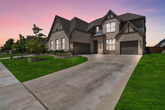 tudor house featuring a lawn and a garage