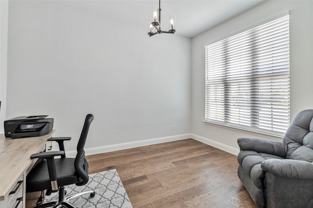 office area with an inviting chandelier, hardwood / wood-style floors, and a healthy amount of sunlight