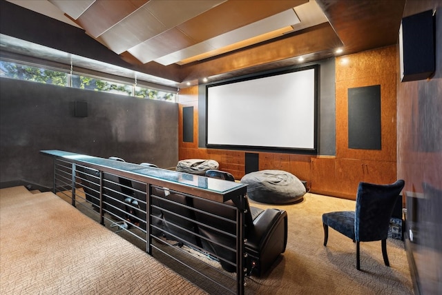 carpeted home theater featuring wooden walls and vaulted ceiling