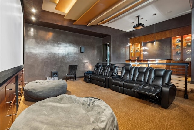 carpeted home theater room with beamed ceiling