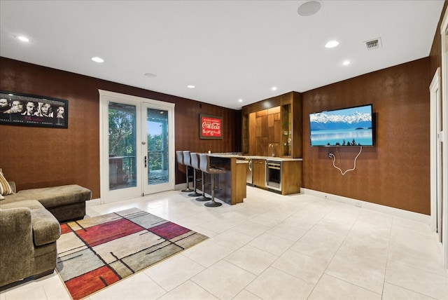 bar with wood walls, light tile patterned floors, and french doors