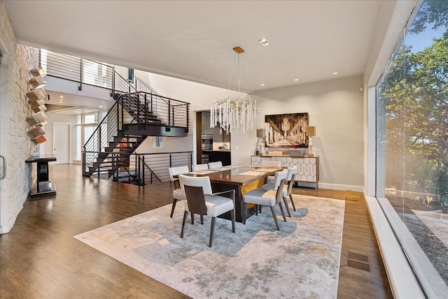 dining space with hardwood / wood-style floors and a notable chandelier