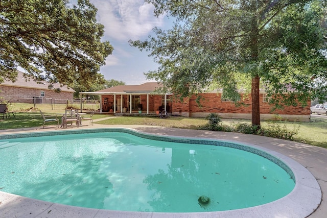 view of swimming pool featuring a yard