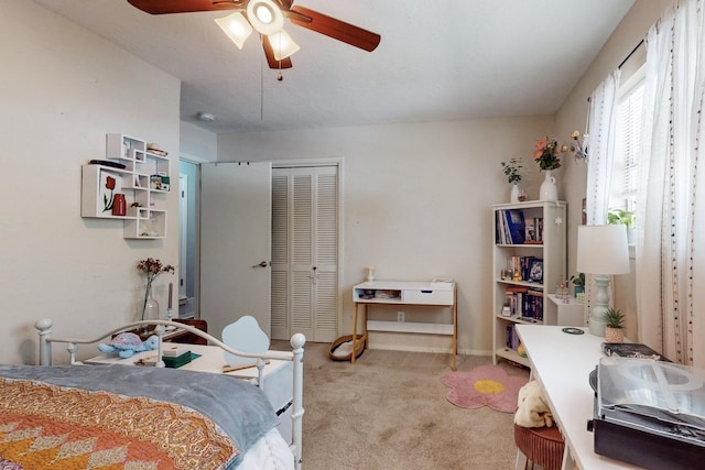 carpeted bedroom featuring a closet and ceiling fan