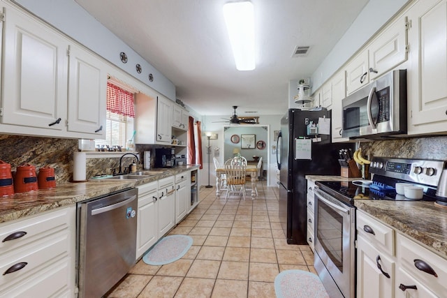 kitchen with appliances with stainless steel finishes, white cabinetry, and sink