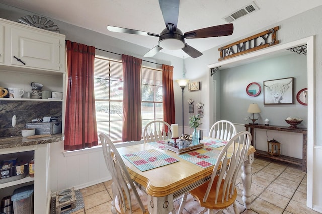 tiled dining space with ceiling fan