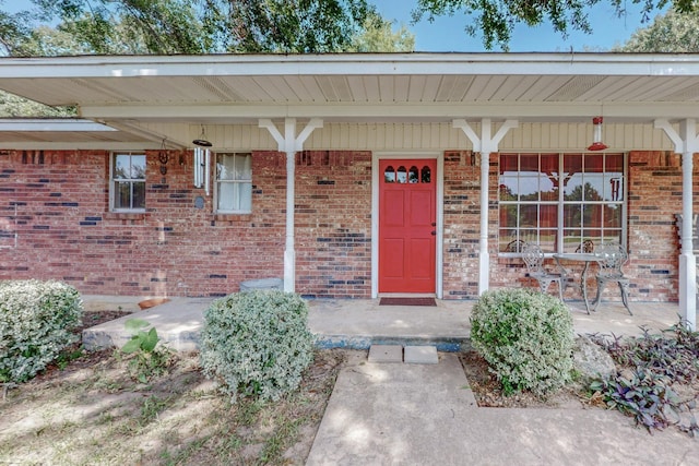 view of exterior entry featuring covered porch