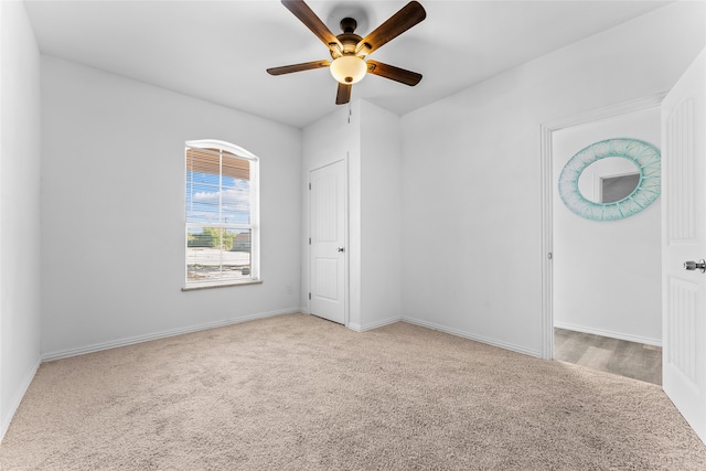 unfurnished room with light colored carpet and ceiling fan