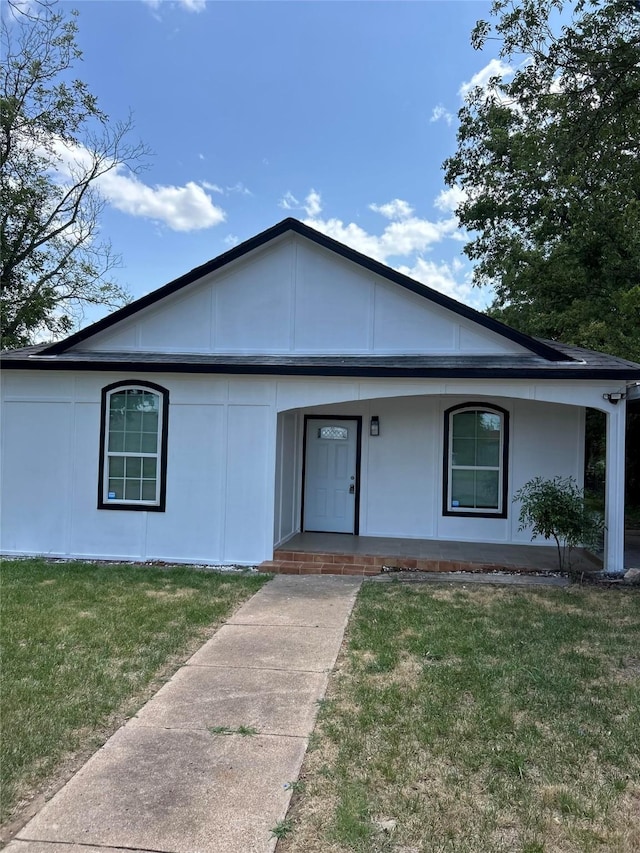 single story home featuring a porch and a front lawn